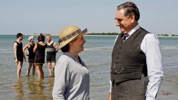 Mrs Hughes et Mr Carson se donnent la main sur une plage.